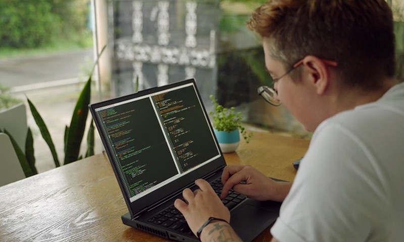 Programer piše kod na laptopu