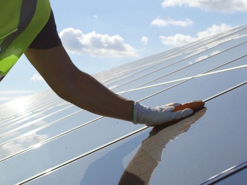 čovek dodiruje solarne panele