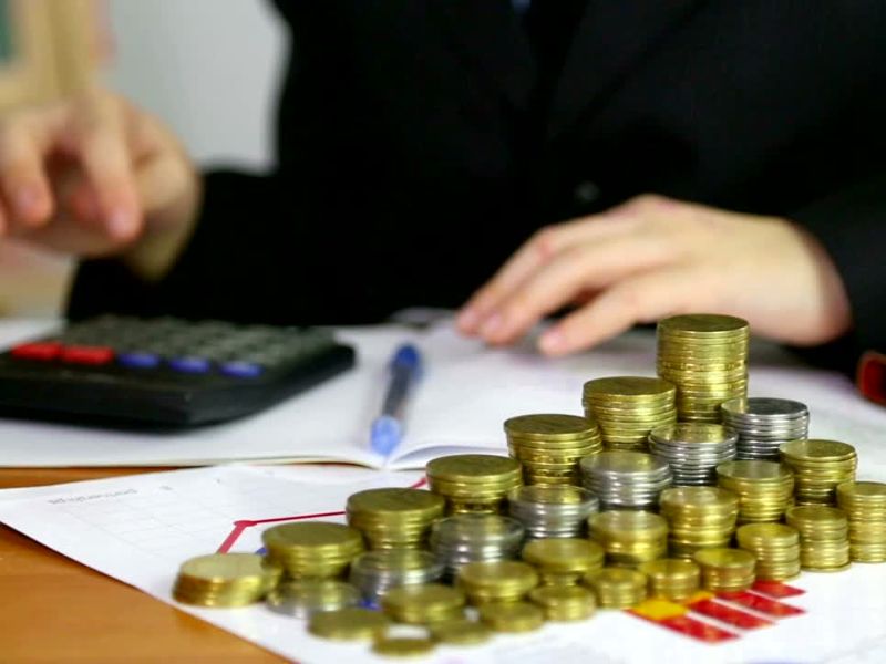 prikaz investitora pored kog stoji novac, kalkulator i papiri