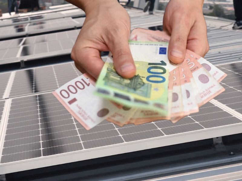 prikaz novca u ruci i solarnih panela u pozadini