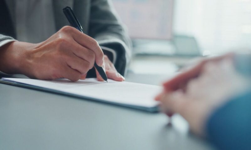 osoba potpisuje predugovor u kupoprodaji stana