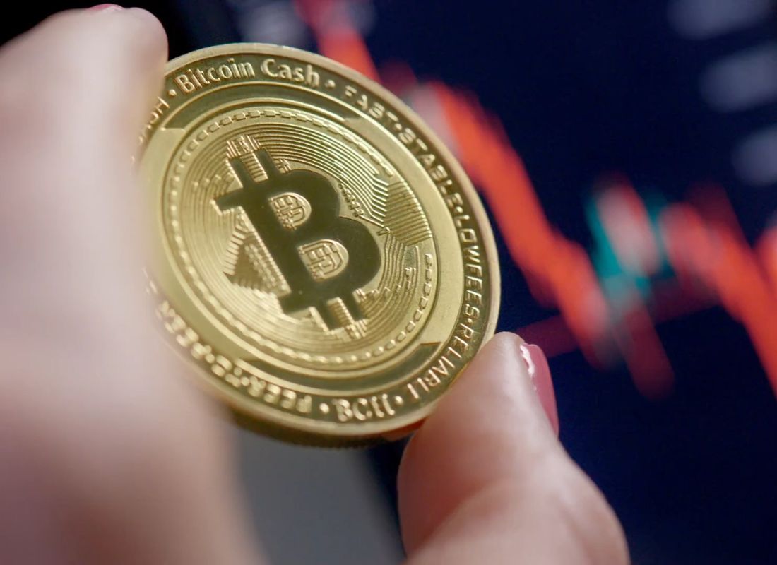 osoba drži bitkoin u ruci