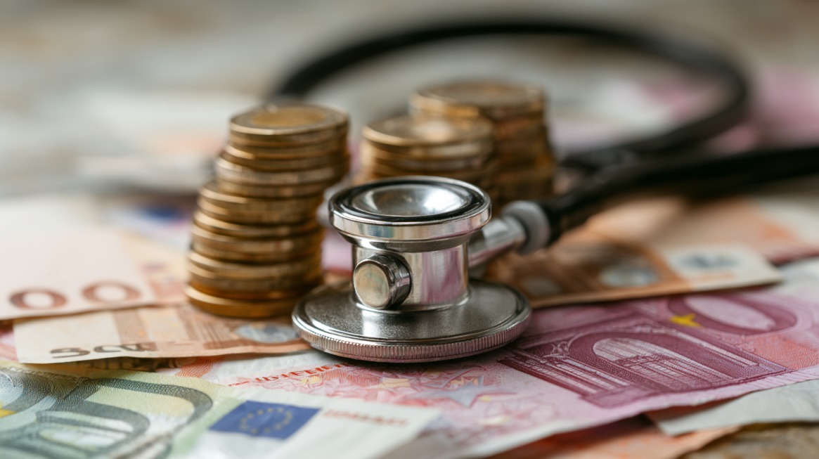 Stetoskop i novac koji simbolizuju troškove i zdravstveno osiguranje