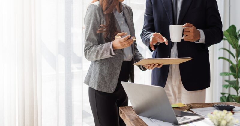 Dvoje poslovnih ljudi analiziraju dokumente i planiraju finansije u kancelariji