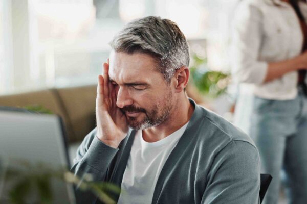 Muškarac zabrinuto gleda u ekran računara u kancelariji