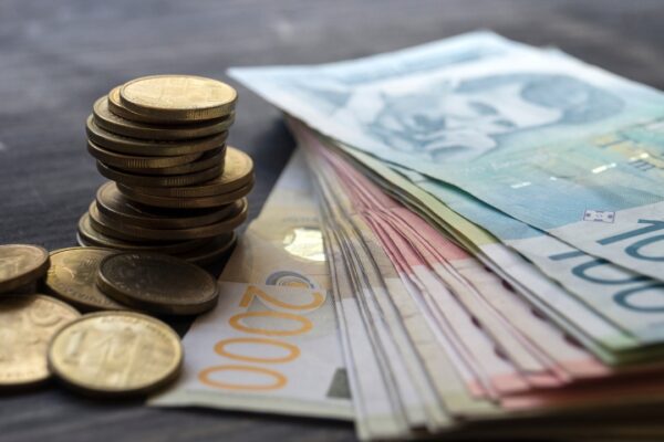 Novčanice i kovanice složene na stolu kao simbol finansija i doprinosa