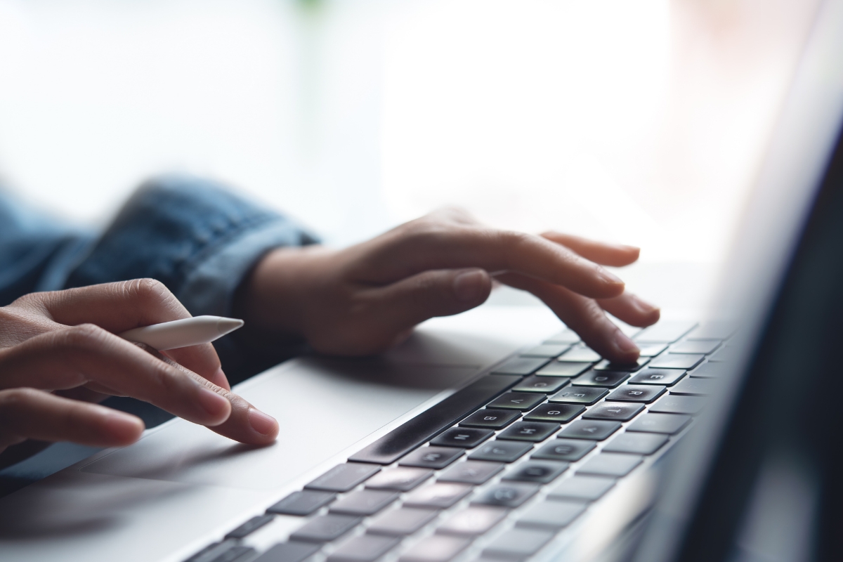 osoba koristi laptop i drži hemijsku u ruci