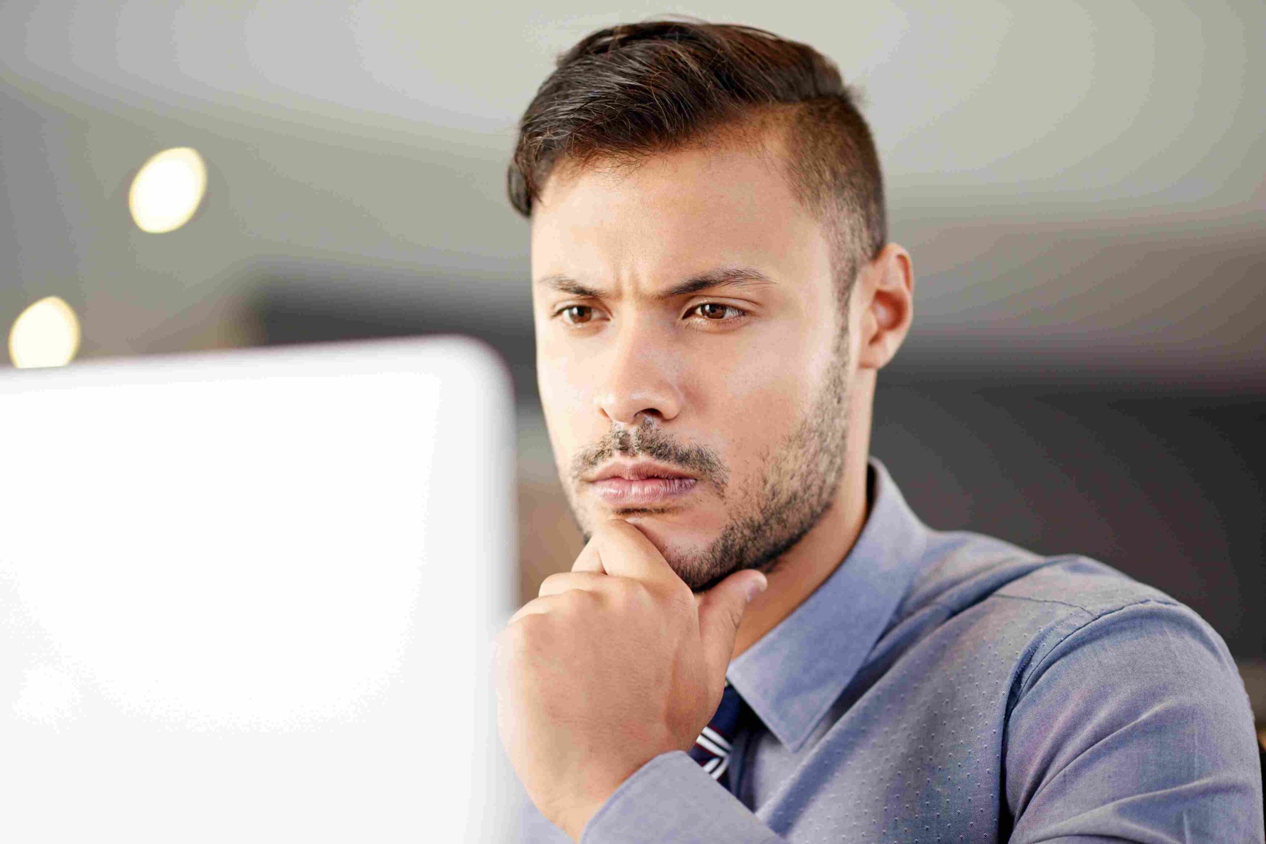 Muškarac razmišlja dok gleda u ekran računara