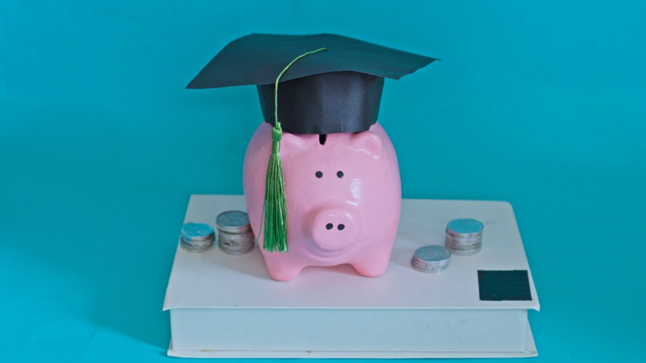 Kasica prasica sa diplomskom kapom i novčićima predstavlja finansijsku podršku studentima