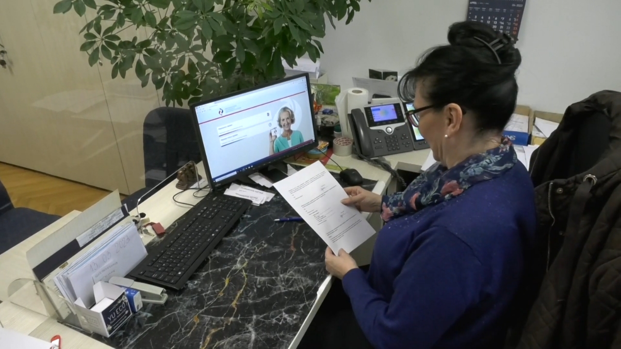Zaposlena u Fondu PIO proverava dokumentaciju uz otvorenu stranicu Penzionerske kartice na računaru.